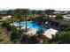 Aerial view of a community pool area with palm trees, lounge chairs, and a covered pavilion at 21617 S 229Th Way, Queen Creek, AZ 85142