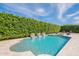 Refreshing pool with water features, complemented by elegant patio furniture and a serene green hedge backdrop at 21617 S 229Th Way, Queen Creek, AZ 85142