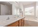 Well-lit bathroom with double sinks, soaking tub, and white countertops at 22300 N Kingston Dr, Maricopa, AZ 85138