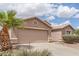 Single-story home showing two-car garage, desert landscaping and large palm tree at 22300 N Kingston Dr, Maricopa, AZ 85138
