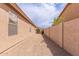 Side yard with gravel, secure block fencing, and pedestrian gate at 22300 N Kingston Dr, Maricopa, AZ 85138