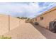 Practical side yard featuring low-maintenance gravel and secure fencing for privacy at 22300 N Kingston Dr, Maricopa, AZ 85138