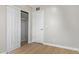 Bright bedroom featuring neutral walls, light floors, closet with doors open, and a white door at 2331 W Hartford Ave, Phoenix, AZ 85023