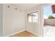 Small bedroom with neutral walls, light floors, a window, and a door to the patio at 2331 W Hartford Ave, Phoenix, AZ 85023