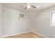 Bright bedroom featuring neutral walls, light floors, ceiling fan, window, and air conditioner at 2331 W Hartford Ave, Phoenix, AZ 85023