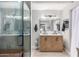 Stylish bathroom with double vanity, chevron wood cabinets, sleek mirrors, and glass-enclosed shower at 23405 N 84Th St, Scottsdale, AZ 85255