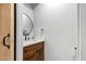 Contemporary half bathroom featuring a wood vanity with stone countertop and round mirror at 23405 N 84Th St, Scottsdale, AZ 85255