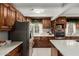 Modern kitchen with stainless steel appliances, light countertops, and dark wood cabinets at 23405 N 84Th St, Scottsdale, AZ 85255