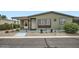 Single-story home with desert landscaping and covered patio with a seating area at 2400 E Baseline Ave # 94, Apache Junction, AZ 85119