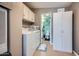 Functional laundry room with washer, dryer, storage cabinet, and a glimpse of the bathroom at 2400 E Baseline Ave # 94, Apache Junction, AZ 85119