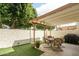 Charming backyard patio with covered seating area, artificial grass, and block wall providing privacy at 2434 W Eugie Ave, Phoenix, AZ 85029