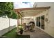Inviting backyard patio with covered dining area, lush artificial grass, and convenient access to the house at 2434 W Eugie Ave, Phoenix, AZ 85029
