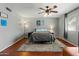Comfortable bedroom with hardwood floors, a ceiling fan, window, and a calming gray color scheme at 2434 W Eugie Ave, Phoenix, AZ 85029