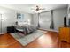 Cozy bedroom featuring a ceiling fan, hardwood floors, a window, and neutral decor at 2434 W Eugie Ave, Phoenix, AZ 85029