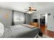 Serene bedroom with wood flooring, ceiling fan, dresser, window, and view to an organized walk-in closet at 2434 W Eugie Ave, Phoenix, AZ 85029