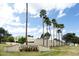 The community entrance has lush landscaping and towering palm trees on a bright and sunny day at 2434 W Eugie Ave, Phoenix, AZ 85029