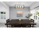 Dining room featuring a modern chandelier, dark wood table, and large picture window at 2818 N Yucca St, Chandler, AZ 85224