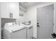 Well-lit laundry room with white washer and dryer, cabinets, and access door at 2818 N Yucca St, Chandler, AZ 85224