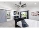 Well-lit main bedroom with TV and view into an en suite bath through sliding barn door at 2818 N Yucca St, Chandler, AZ 85224