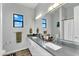 Elegant bathroom with dual sinks, gray countertops, and large mirrors offering bright natural lighting at 28204 N Royce Rd, Queen Creek, AZ 85144