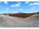 Home exterior featuring a private fence in a desert landscape under a blue sky at 28204 N Royce Rd, Queen Creek, AZ 85144