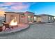The exterior boasts a cozy fire pit with desert landscaping and a charming facade at 28204 N Royce Rd, Queen Creek, AZ 85144
