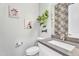 Stylish half bathroom with decorative wallpaper, modern vanity, and unique wall art at 28204 N Royce Rd, Queen Creek, AZ 85144