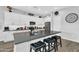 Modern kitchen boasts white cabinets, a black countertop island with seating, and stainless steel appliances at 28204 N Royce Rd, Queen Creek, AZ 85144