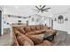 Spacious living room features a large sectional sofa, ceiling fan, and opens to the modern kitchen at 28204 N Royce Rd, Queen Creek, AZ 85144
