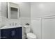 Stylish bathroom with a blue vanity, sleek mirror, and modern fixtures with a white water closet at 2900 E Spring Wheat Ln, Gilbert, AZ 85296