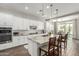 Well-lit kitchen features an island with granite countertops, wooden barstools, and pendant lighting at 2900 E Spring Wheat Ln, Gilbert, AZ 85296