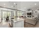 Open floor plan with kitchen island, dining area, living room with fireplace and a ceiling fan at 2900 E Spring Wheat Ln, Gilbert, AZ 85296