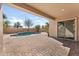 Covered patio features brick pavers, a sparkling pool with a water feature, and easy access through sliding glass doors at 3557 S Halsted Ct, Chandler, AZ 85286