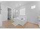 Bright primary bathroom with soaking tub, tile flooring, and open doorway leading to the shower and sink area at 3557 S Halsted Ct, Chandler, AZ 85286
