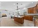 Open-concept kitchen with an island, pendant lights, stainless appliances, and access to the living and dining areas at 3557 S Halsted Ct, Chandler, AZ 85286