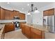 Gourmet kitchen with a large island, pendant lights, granite countertops, stainless appliances, and ample cabinet space at 3557 S Halsted Ct, Chandler, AZ 85286