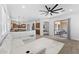 Open concept living room with a white sectional, ceiling fan, and sliding glass doors leading to an outdoor patio at 3557 S Halsted Ct, Chandler, AZ 85286