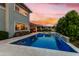 A serene backyard featuring a pool, manicured landscaping, and a calming sunset sky at 3749 E Sagebrush St, Gilbert, AZ 85296