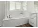 Bright bathroom featuring a soaking tub with stylish fixtures and a window with plantation shutters at 3749 E Sagebrush St, Gilbert, AZ 85296