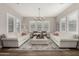 Bright living room with white sofas, plantation shutters, decorative rug and chandelier at 3749 E Sagebrush St, Gilbert, AZ 85296