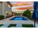 A beautiful pool area with lounge chairs, lush greenery, and a stunning sunset backdrop for evening relaxation at 3749 E Sagebrush St, Gilbert, AZ 85296