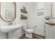 Stylish powder room with a pedestal sink, decorative mirror, and sleek fixtures at 3749 E Sagebrush St, Gilbert, AZ 85296