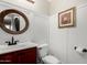 Elegant powder room features wood-trimmed mirror, charming sconces, and wainscoting panel detail at 3882 W Goldmine Mountain Dr, San Tan Valley, AZ 85144