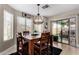 Well-lit dining room features wood table, black rug, chandelier, and sliding glass door to backyard at 3882 W Goldmine Mountain Dr, San Tan Valley, AZ 85144