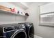 The laundry room has modern washer and dryer machines, plus ample shelving for storage at 3882 W Goldmine Mountain Dr, San Tan Valley, AZ 85144