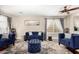 Living room with hardwood floors, blue velvet seating, a ceiling fan, and natural light at 3882 W Goldmine Mountain Dr, San Tan Valley, AZ 85144
