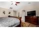 Spacious main bedroom with ceiling fan, wood-look floors, warm colors, sitting area and accent rug at 3882 W Goldmine Mountain Dr, San Tan Valley, AZ 85144