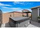 View of the backyard featuring a covered hot tub with a patio and block fence surround at 40610 W Desert Fairways Dr, Maricopa, AZ 85138