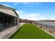 Spacious backyard features artificial turf and lake views at 40610 W Desert Fairways Dr, Maricopa, AZ 85138