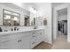 Elegant bathroom featuring double sinks, modern fixtures, and neutral decor, with access to a walk-in closet at 40610 W Desert Fairways Dr, Maricopa, AZ 85138